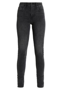 Jeans skinny de cintura alta en un tejido de denim gris oscuro. Cuenta con cinco bolsillos y un cierre clásico de botón. Textura suave y forma ajustada.