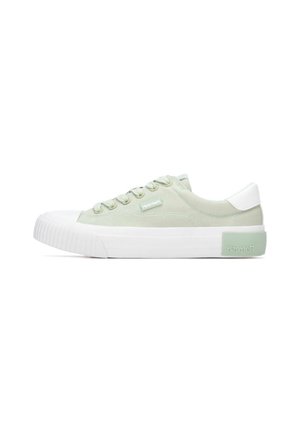 Zapatillas de lona color verde claro con puntera y contrafuerte de goma blanca, cordones redondos y un detalle de marca en el lateral.
