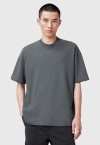 Mörkgrå bomulls t-shirt med korta ärmar, rund hals och en liten broderad grafik på vänster bröst. Avslappnad passform, mjuk textur.