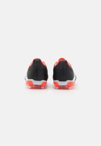 Botas de fútbol negras y naranjas con un acabado suave, que presentan una suela blanca y seis tacos para tracción, diseñadas para el juego al aire libre.