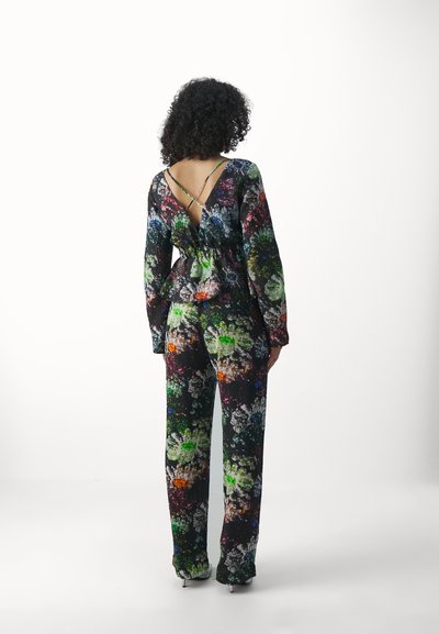 Combinaison florale noire avec des fleurs multicolores. Dotée d'un dos en V profond, de manches longues et d'une coupe décontractée avec une taille élastique.
