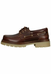 Braune Lederbootsschuhe mit abgerundeter Zehenpartie, zwei Ösen und Schnürung, goldenen Beschlägen und einer dicken beigen Gummisohle mit einem Profilmuster.