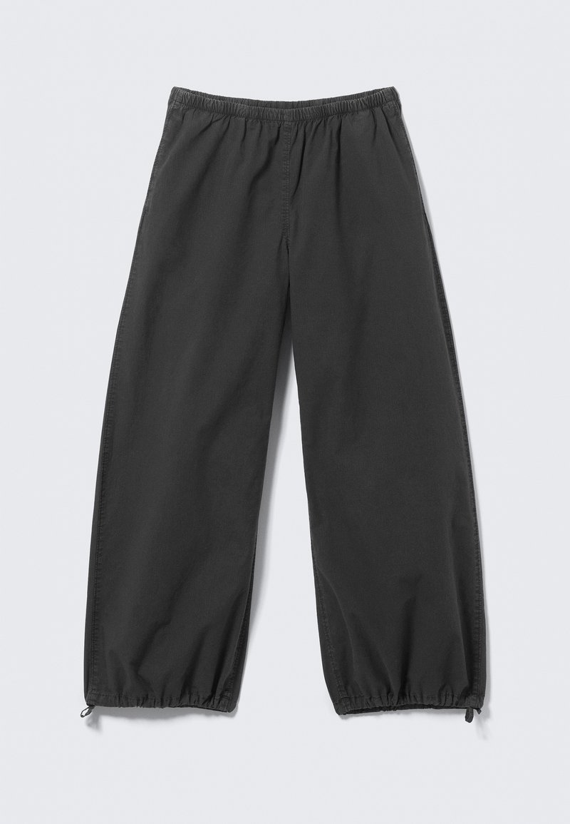 Pantalon noir à coupe ample avec taille élastique et ourlets à cordon de serrage ajustable, posé à plat sur un fond clair.