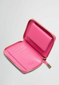 Portafoglio di pelle rosa con zip dorata, dotato di più scomparti per carte e un portacarte separato. L'interno ha una texture liscia.