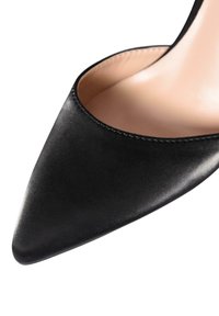 Scarpa con tacco alto nera a punta, realizzata in materiale liscio con un design a taglio basso, caratterizzata da una fodera interna beige e dettagli di cucitura sottili.