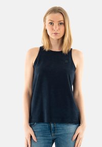 Top sin mangas azul marino de una tela suave, con escote redondo y un discreto detalle del logo en el lado izquierdo. Corte informal.