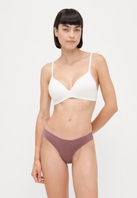Witte plunge beha met dunne bandjes en een gladde textuur, gecombineerd met een mauve minimalistische string in een zacht, rekbaar materiaal.