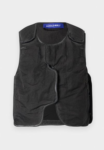 Gilet noir en tissu texturé, encolure arrondie, fermeture avant asymétrique et poches latérales. Présente une étiquette de marque bleue au col.