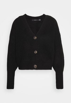 Zwarte cropped cardigan met een textuur gebreid patroon, met een diepe V-hals en drie ronde knopen aan de voorkant. Lange, iets gepofte mouwen.