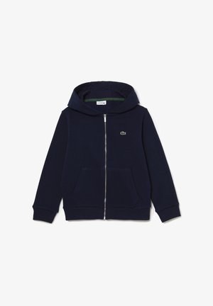 Námornícky zipsový hoodie vyrobený z bavlny, s klokankovou kapsou, rebrovanými manžetami a malým zeleným logom na hrudi. Hladká textúra.