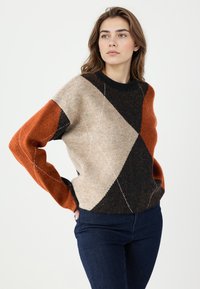 Pull en tricot avec un motif géométrique orange, noir et beige, col rond et manches longues avec des poignets côtelés.