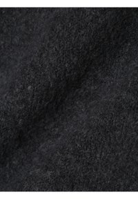 Svart tyg närbild, texturerad ull med en mjuk, ludden yta. Materialet visar ett lätt marmorerat mönster som framhäver olika nyanser av svart.