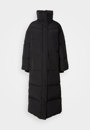 Casaco de puffer longo e preto com colarinho alto, mangas largas e seções acolchoadas verticais, apresentando um design frontal limpo e fechado.