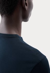 Schwarzes Baumwoll-T-Shirt mit Rundhalsausschnitt, von hinten gezeigt. Glatte Textur, kurze Ärmel und saubere Nähte am Kragen.