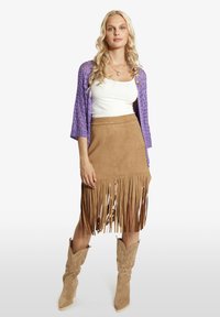 Violetinė megzta kardiganas, balta tankų palaidinė, ruda zomšinė sijonas su pūtimais, ir smėlio spalvos kaubojiški batai su raštuotais detalėmis. Tekstūruotas ir sluoksniuotas įvaizdis.