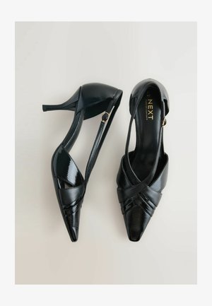 Fekete magassarkú cipők, lakkbőrből készült, hegyes orral, keresztbe tett pántokkal és arany díszítéssel.