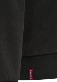 Zwarte sweatshirt van een zachte katoenmix, met een ribbelboord aan de onderkant en manchetten. Een rood merketiket is zichtbaar aan de linksonder naad.