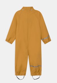 Gul vattentät overall med långa ärmar, elastiska muddar och reflekterande detaljer. Har tryckknappstängning vid kragen och justerbara fotöglor.