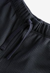 Schwarze, strukturierte Shorts aus einem karierten Stoff mit einem elastischen Bund und Zugband. Das Material hat ein weiches, gewebtes Aussehen.