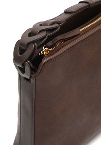 Borsa a mano in pelle marrone con finitura testurizzata, caratterizzata da una maniglia decorativa a catena e un'accents dorato sulla cerniera in cima.