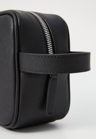 Black synthetic leather toiletry bag with a rectangular shape, smooth texture, silver zipper, and a side carrying handle.