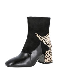 Botín negro de ante hasta el tobillo con punta afilada, tacón de leopardo en contraste y acentos de cuero negro suave. Detalle de tacón bloque claro y resistente.