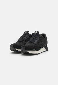 Scarpe sportive nere con una tomaia texturizzata, dotate di lacci, punta rinforzata e suola intermedia bianca a contrasto. Suola in gomma resistente.