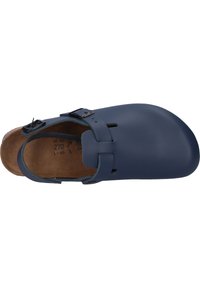 Marineblaue Slipper mit zwei verstellbaren schwarzen Schnallen, offener Ferse und strukturiertem braunem Fußbett. Glatte Außenseite mit Ausschnitten.