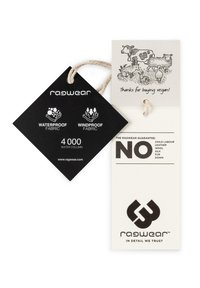Étiquette en tissu noir avec des textes blancs présentant des symboles "imperméable" et "coupe-vent" ; une étiquette crème attachée présente des illustrations d'animaux et un message végétalien.