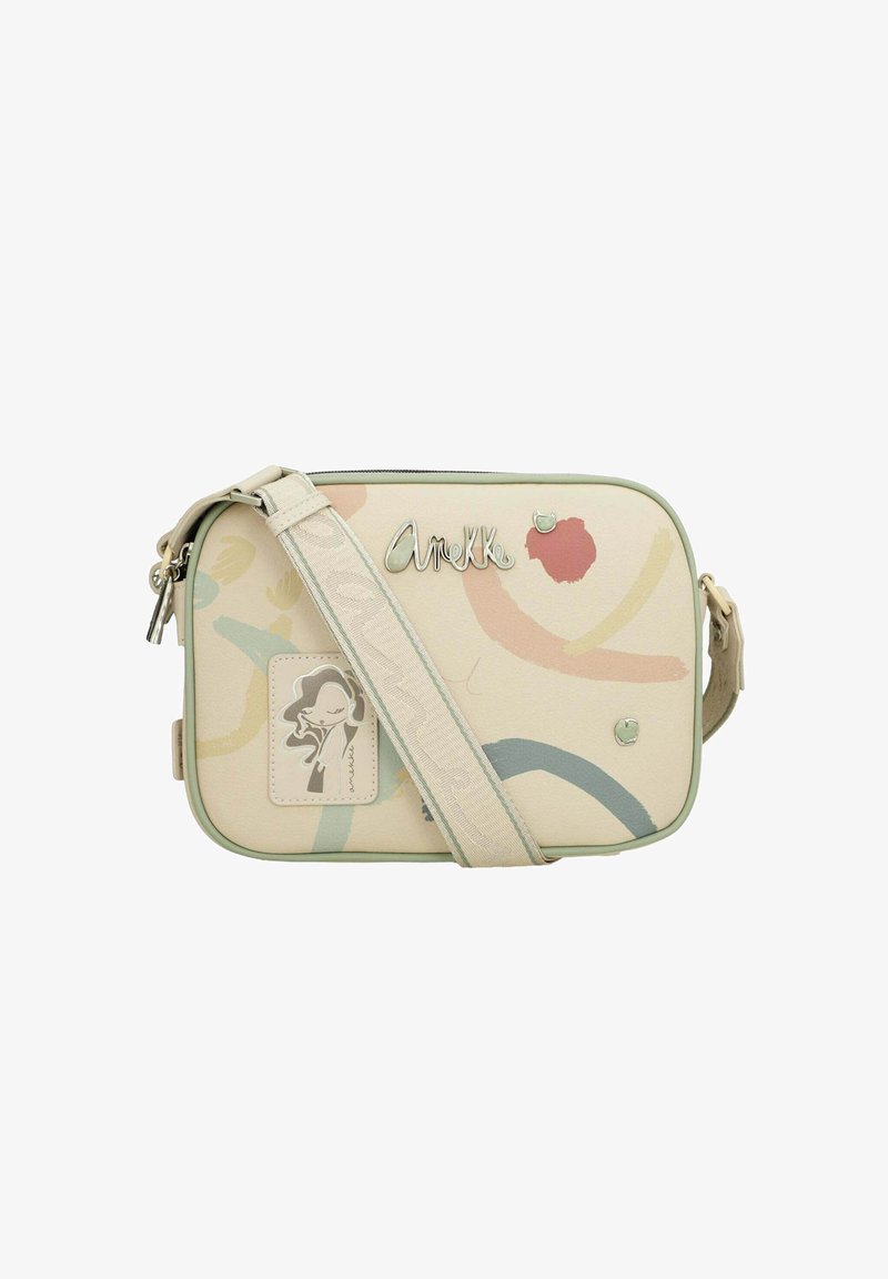 Bolso cruzado beige con patrones abstractos coloridos, herrajes plateados, una etiqueta decorativa y una correa verde. Cierre con cremallera, forma rectangular.