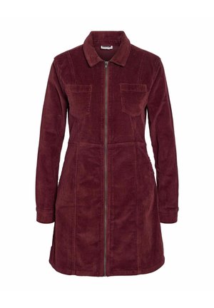 Bordeaux corduroy-mekko pitkilla hihoilla, vetoketju edessä, kaksi rintataskua ja viisikulmainen kaulus. Tekstuuri kangas pehmeällä pinnalla.