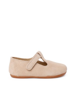 Chaussure pour tout-petit en daim beige avec un bout arrondi, une bride à scratch et une semelle souple marron clair, vue de profil sur un fond blanc.
