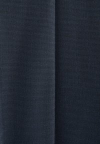 Tissu à petits carreaux bleu foncé et noir avec une couture verticale centrale séparant deux panneaux.
