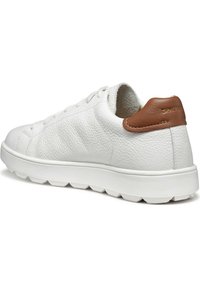 Sneaker en cuir blanc avec surface texturée, semelle crème et accent en cuir marron au niveau du talon. Présente des perforations près des lacets pour une meilleure respirabilité.