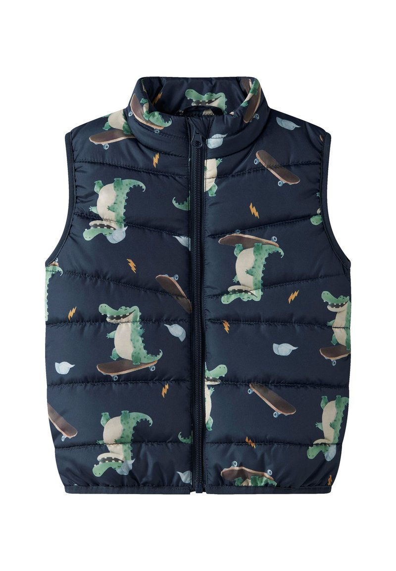 Επενδεδυμένο, αμάνικο γιλέκο σε ναυτικό μπλε χρώμα με στάμπα καρτούν δεινοσαύρου που κάνει πατίνι, με όρθιο γιακά και εμπρόσθιο φερμουάρ.
