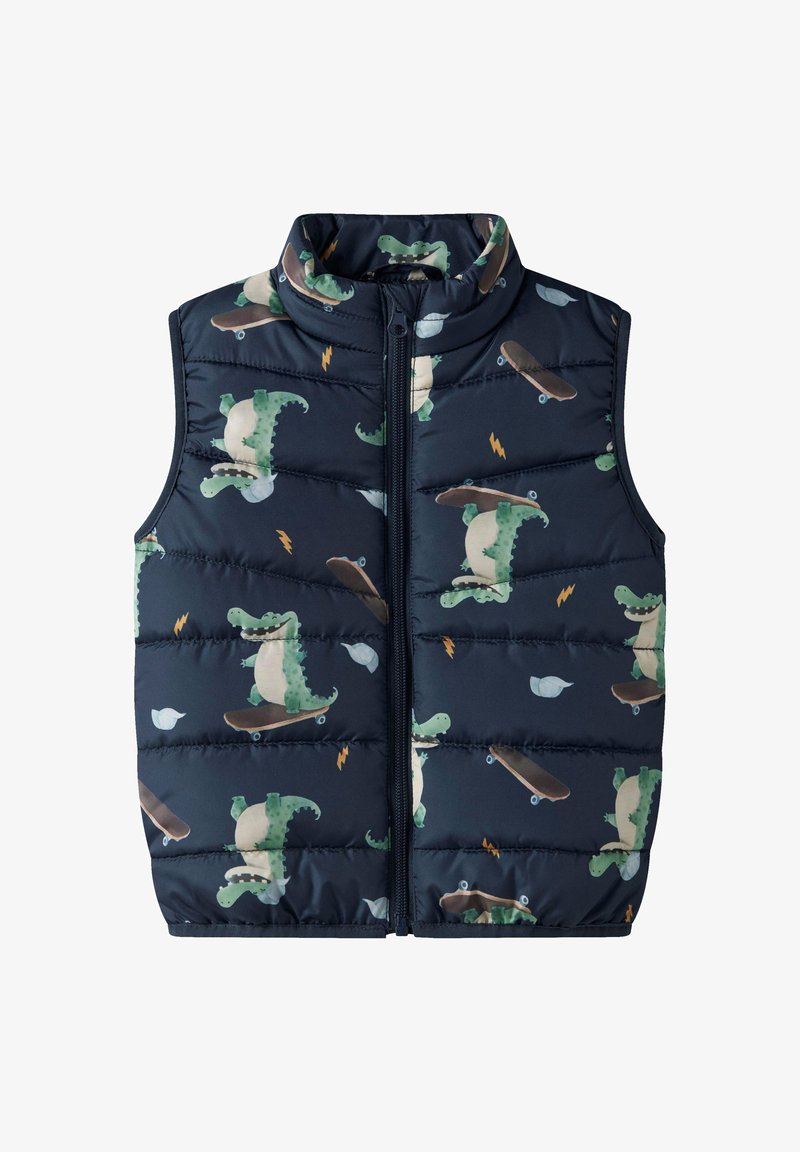 Επενδεδυμένο, αμάνικο γιλέκο σε ναυτικό μπλε χρώμα με στάμπα καρτούν δεινοσαύρου που κάνει πατίνι, με όρθιο γιακά και εμπρόσθιο φερμουάρ.