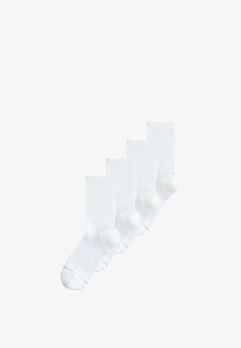 Quatre chaussettes de sport blanches avec des bords côtelés et des talons renforcés, disposées en chevauchement sur un fond blanc.