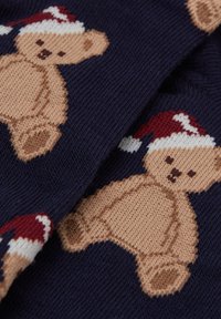 Calze lavorate a maglia con sfondo blu navy e orsetti marrone chiaro che indossano cappelli da Babbo Natale rossi e bianchi, con dettagliati tratti del viso.