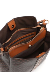 Binnenkant van een bruine stoffen handtas met bruine leren accenten, meerdere compartimenten, waaronder een ritsvak en een magneetsluiting.