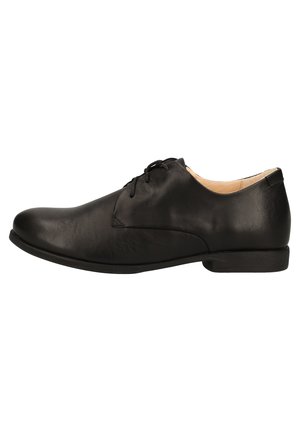 Chaussure habillée en cuir noir avec une finition lisse et mate, bout arrondi et système de laçage. Elle dispose d'un talon bas et d'un minimalisme dans les détails.