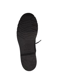 Semelle de chaussure en caoutchouc noir avec un motif de semelle prononcé, comportant un logo circulaire et des rainures de renforcement pour une meilleure adhérence.