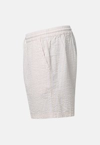 Shorts en tissu seersucker beige clair et blanc avec taille élastiquée et poches latérales, vus de profil sur un fond uni.