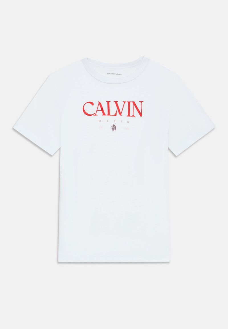 Balta kokvilnas T-kreklu ar īsām piedurknēm, ar sarkanu "CALVIN KLEIN" logotipu priekšpusē. Klasiska apaļa apkakle, bez papildu rakstiem vai akcentiem.