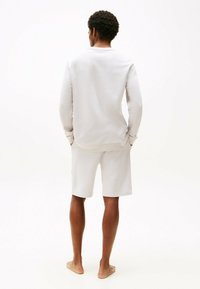 Felpa grigia chiara e pantaloni corti abbinati, tessuto morbido, vestibilità rilassata, maniche lunghe, polsini e vita a coste; design semplice senza motivi.