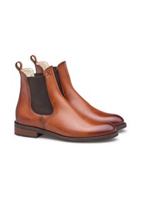 Brown leather Chelsea boots with elastic side panels, round toe, contrasting dark brown accents, and pull tabs on the back for easy wear.
