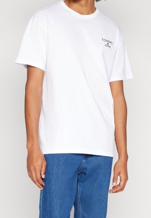 Biała bawełniana koszulka z krótkimi rękawami, okrągłym dekoltem i małym czarnym logo "TOMMY JEANS" na lewej piersi.