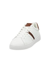 Valkoinen nahkainen tennari, jossa on ruskeita yksityiskohtia, pyöreä varvas, litteä valkoinen pohja ja klassinen nauhakiinnitys, jossa on logo yksityiskohtana kielellä.