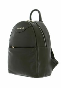 Sac à dos en cuir vert avec un design arrondi, accents en matériel doré, poche zippée à l'avant et poignée supérieure pour le transport. Étiquette de la marque visible.