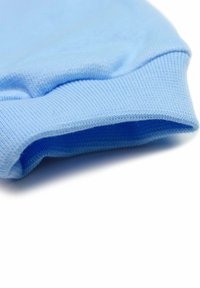 Jasnoniebieski bawełniany mankiet hoodie o prążkowanej teksturze i starannie wykończonych krawędziach, podkreślający miękkość i elastyczność.