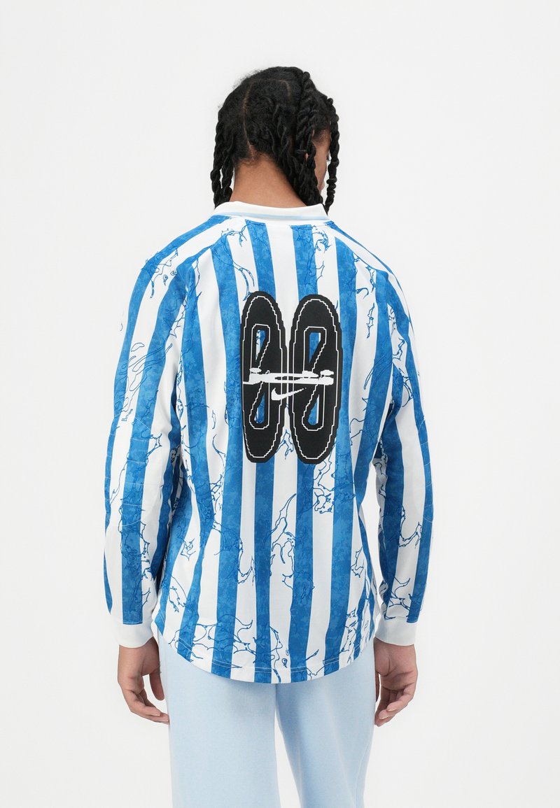 Camisa de manga larga con rayas verticales azules y blancas, patrón veteado y un gran "88" bordado en negro en la parte trasera. Puños blancos.